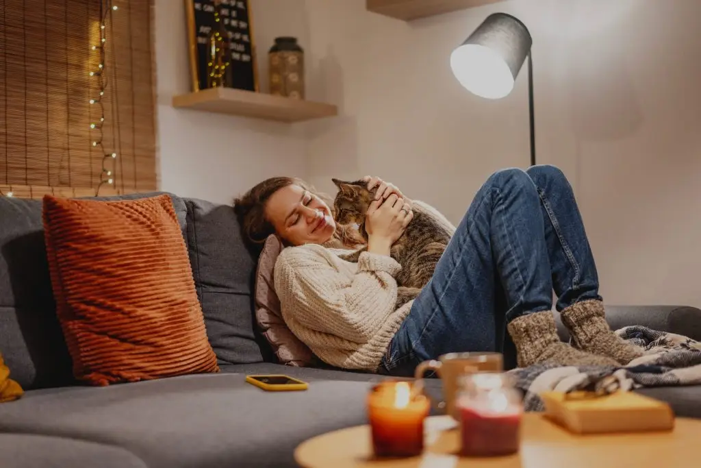 Woman sitting on her couch holding a cat