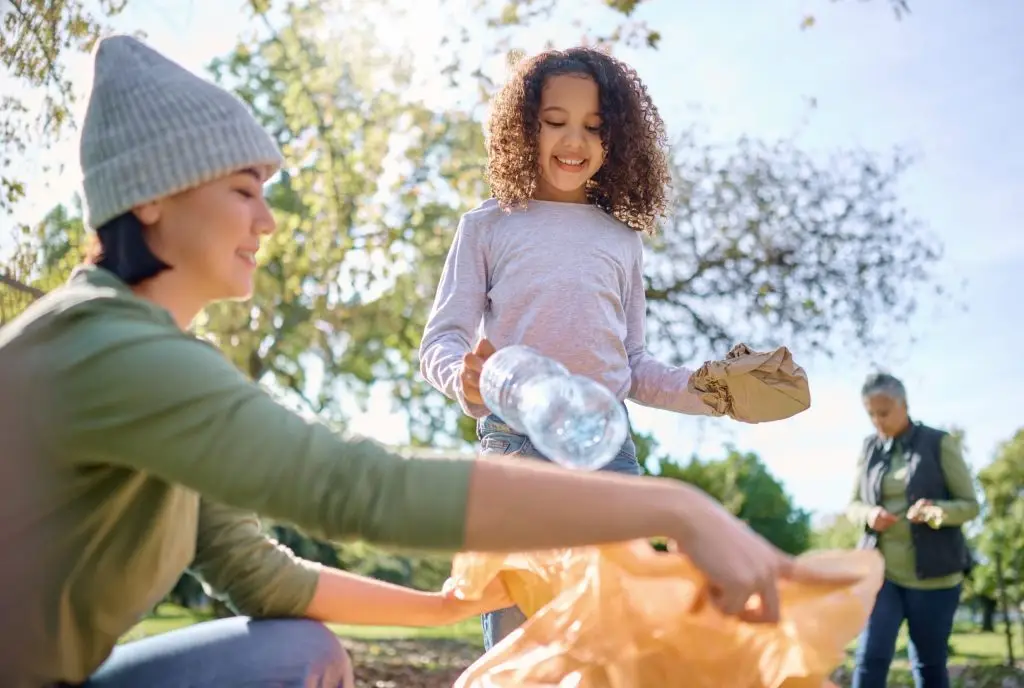 Volunteers putting trash into a bag as part of an Earth day cleanup