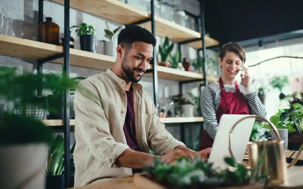 Employee at a small business garden center working at a computer