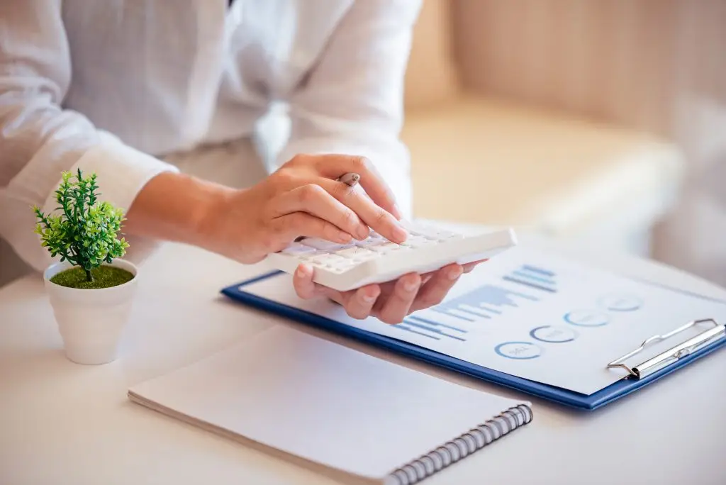 Closeup of someone using a calculator while reviewing financing documents