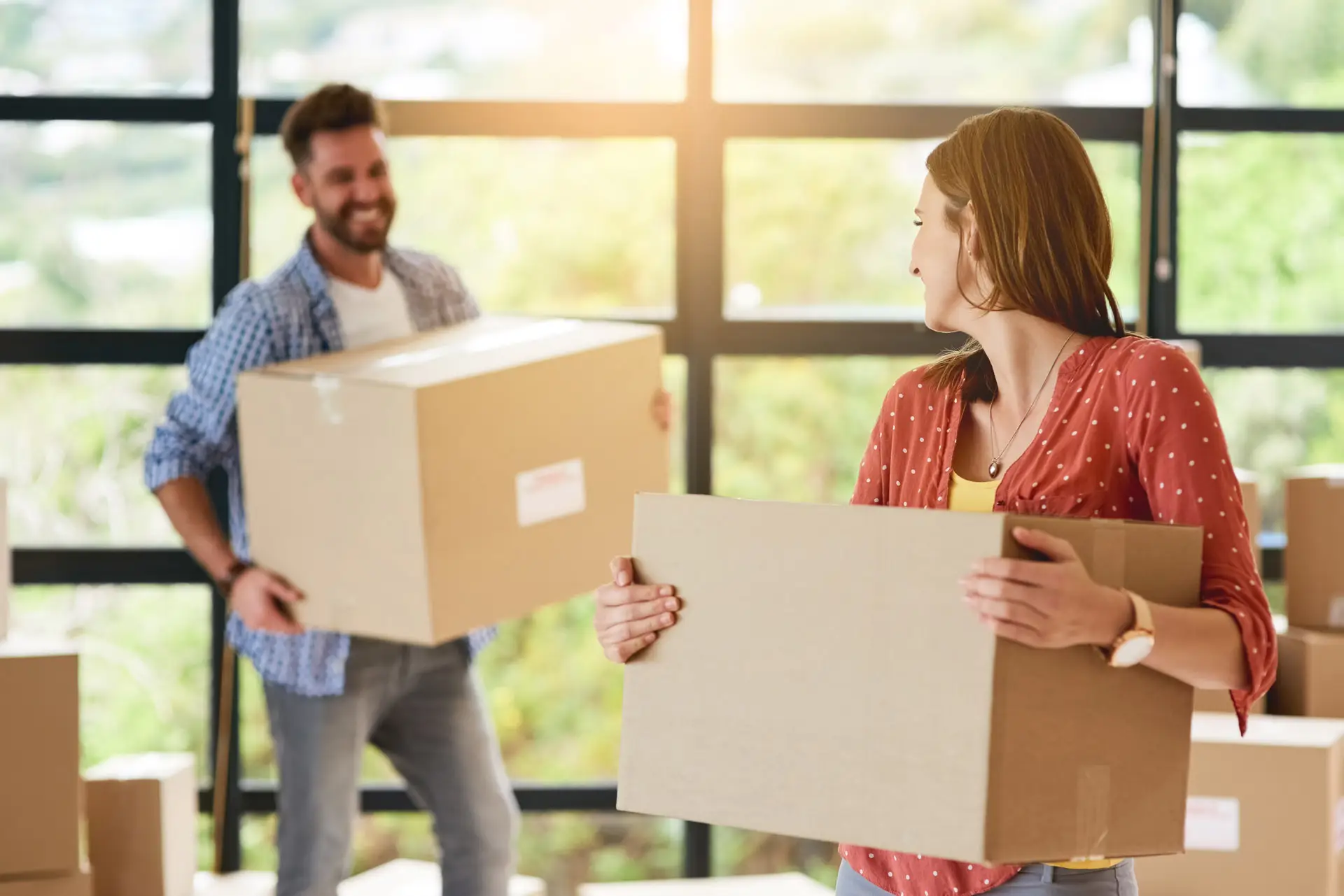 Couple moving boxes into their new home