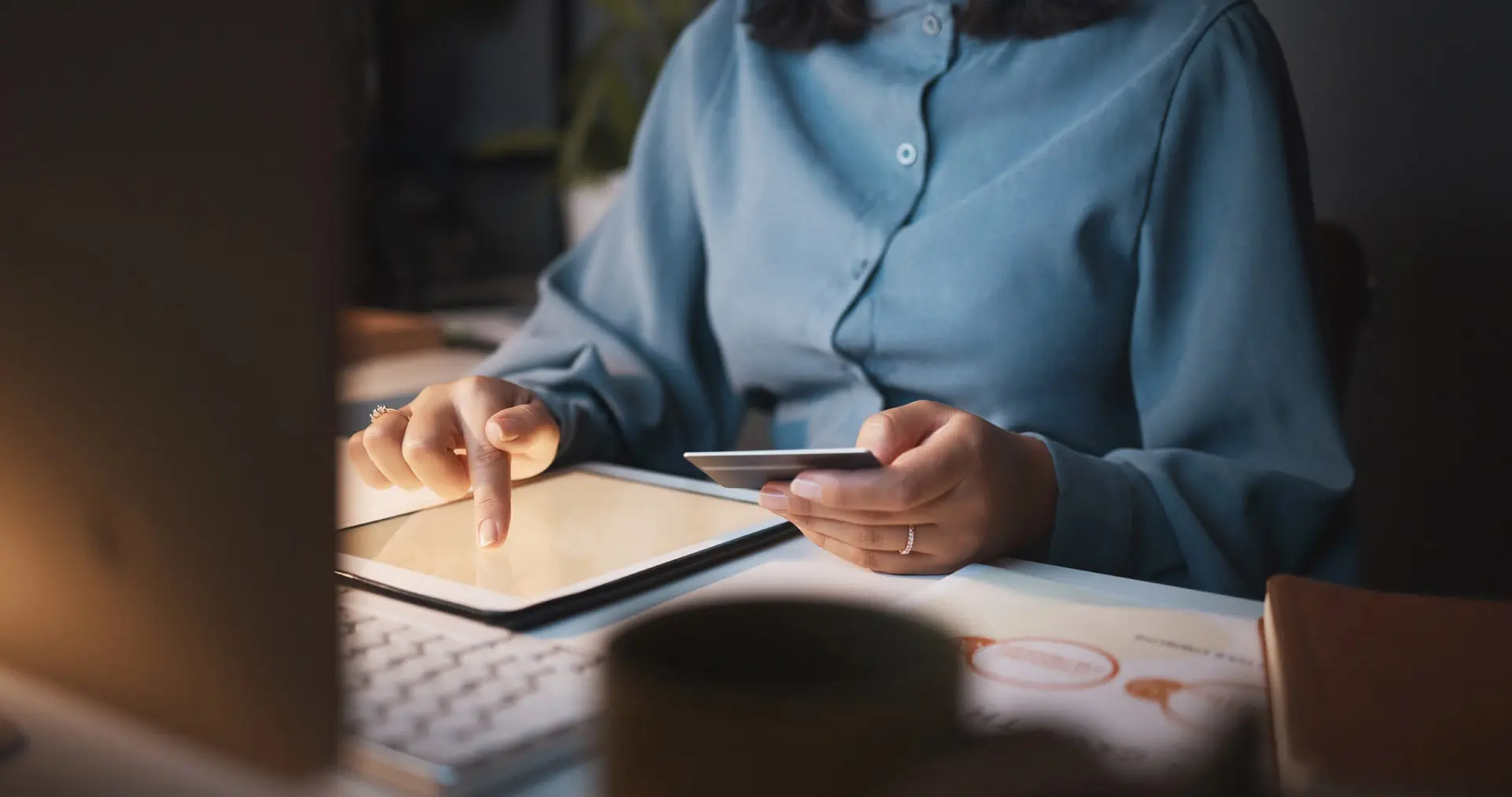 Person holding a credit card and using a tablet
