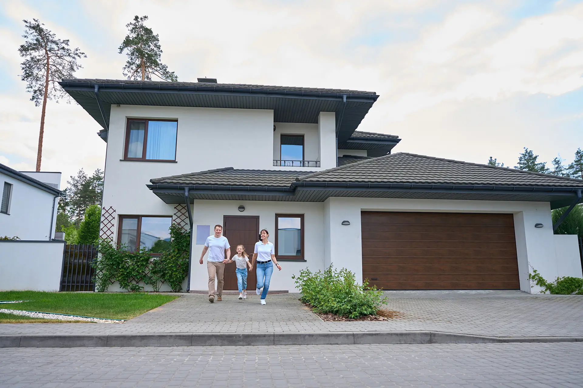 Family smiling in front of their home