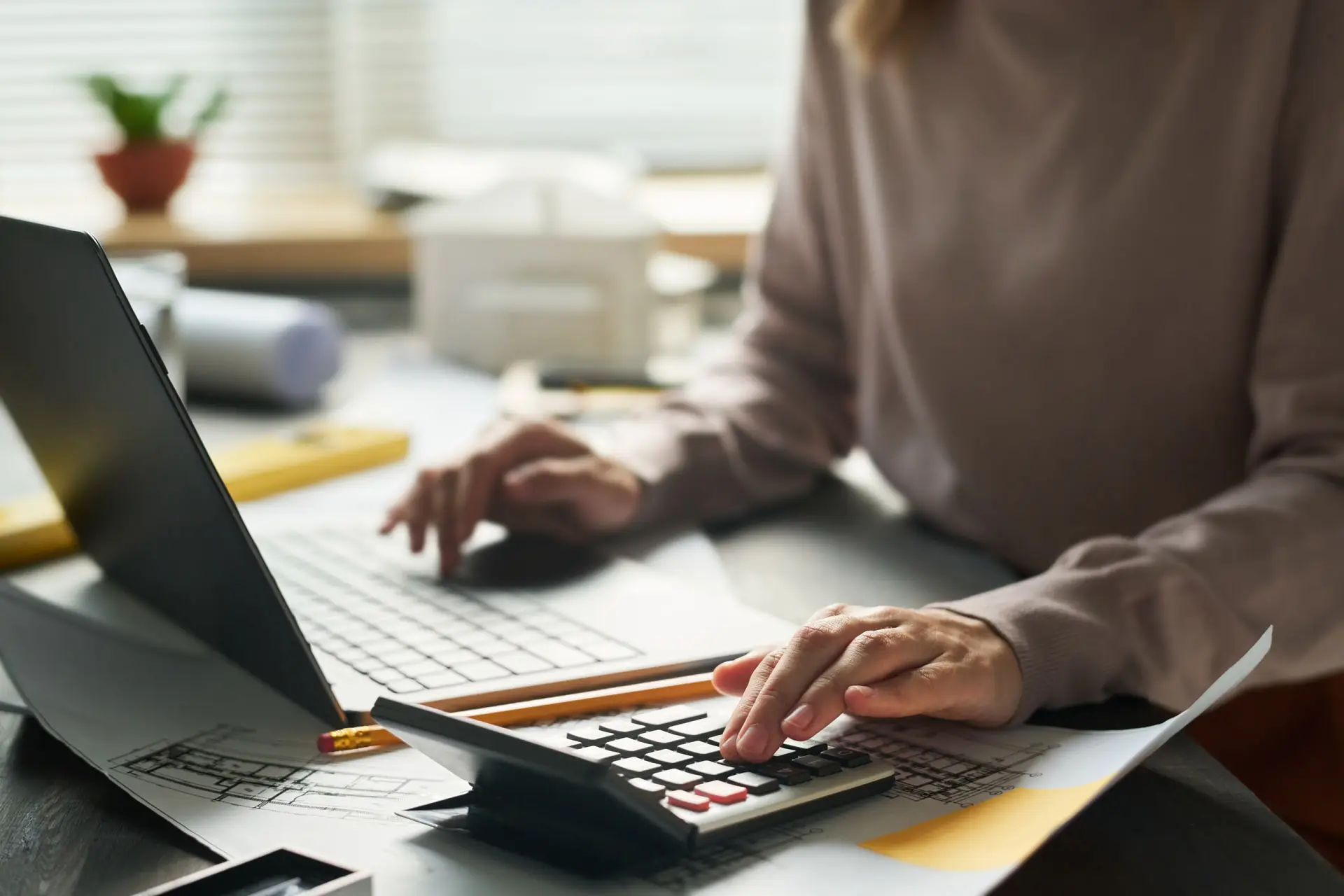 Closeup of a woman financial planning with a laptop and calculator