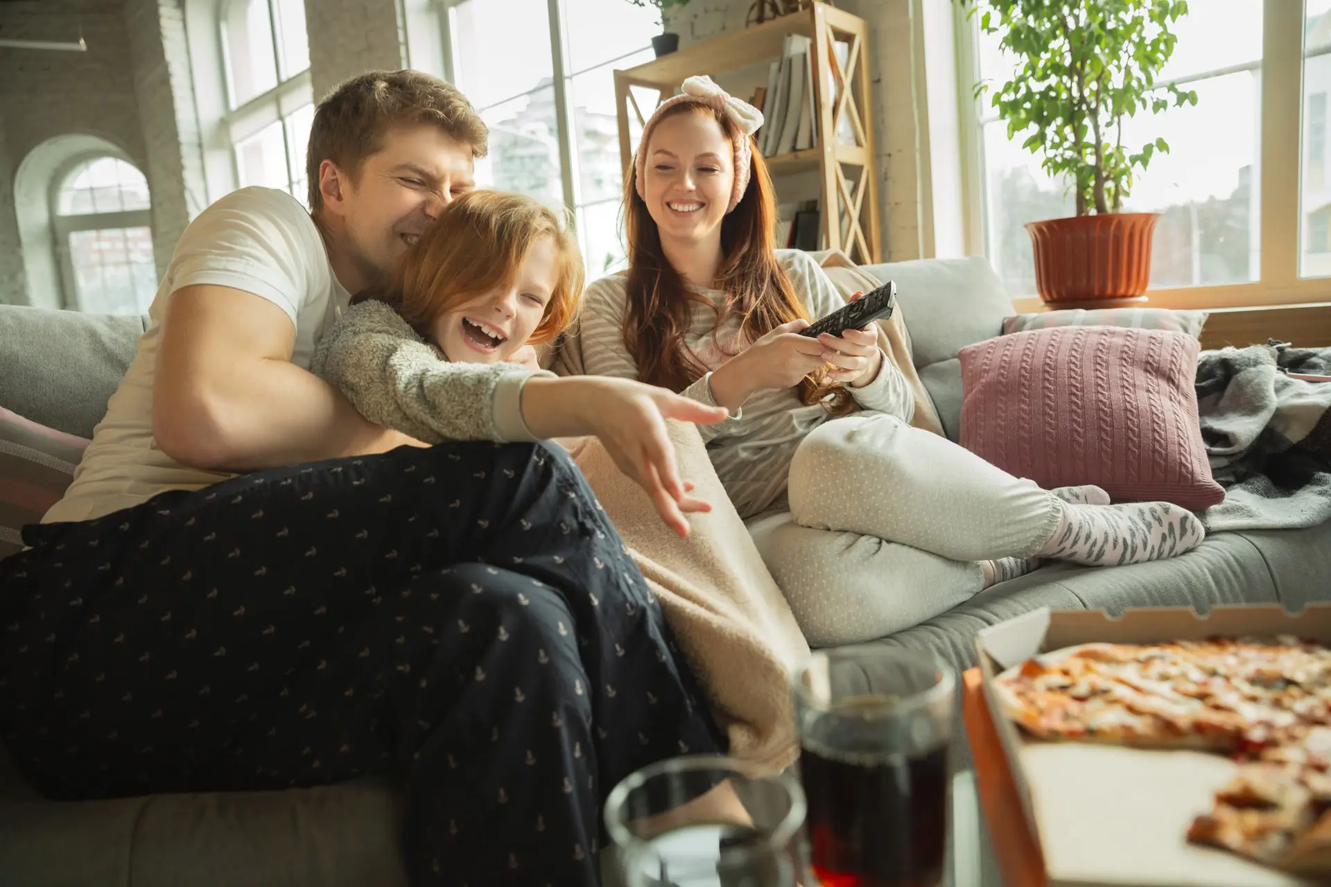Family laughing on their sofa together