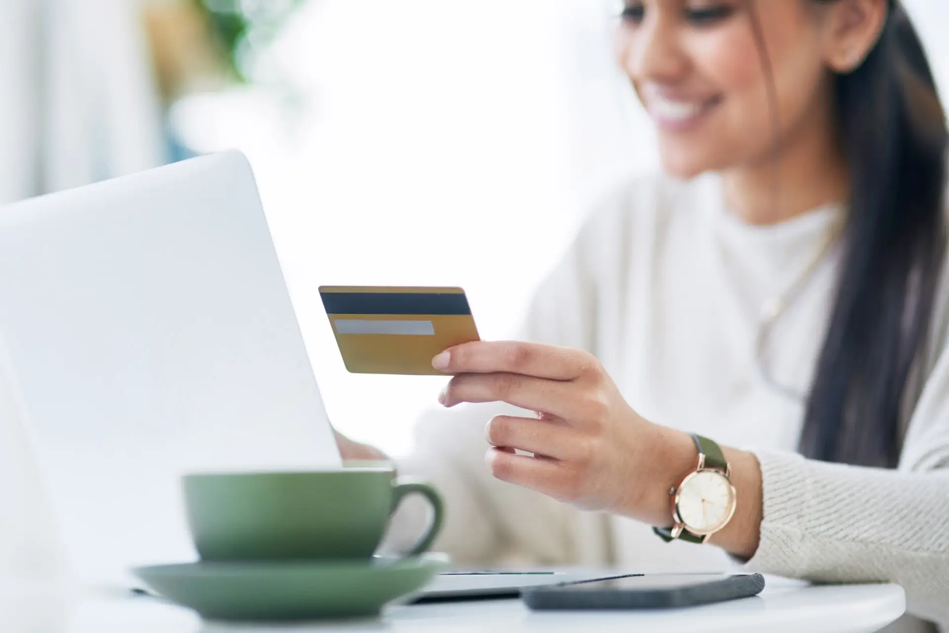 Woman holding a credit card while using her laptop