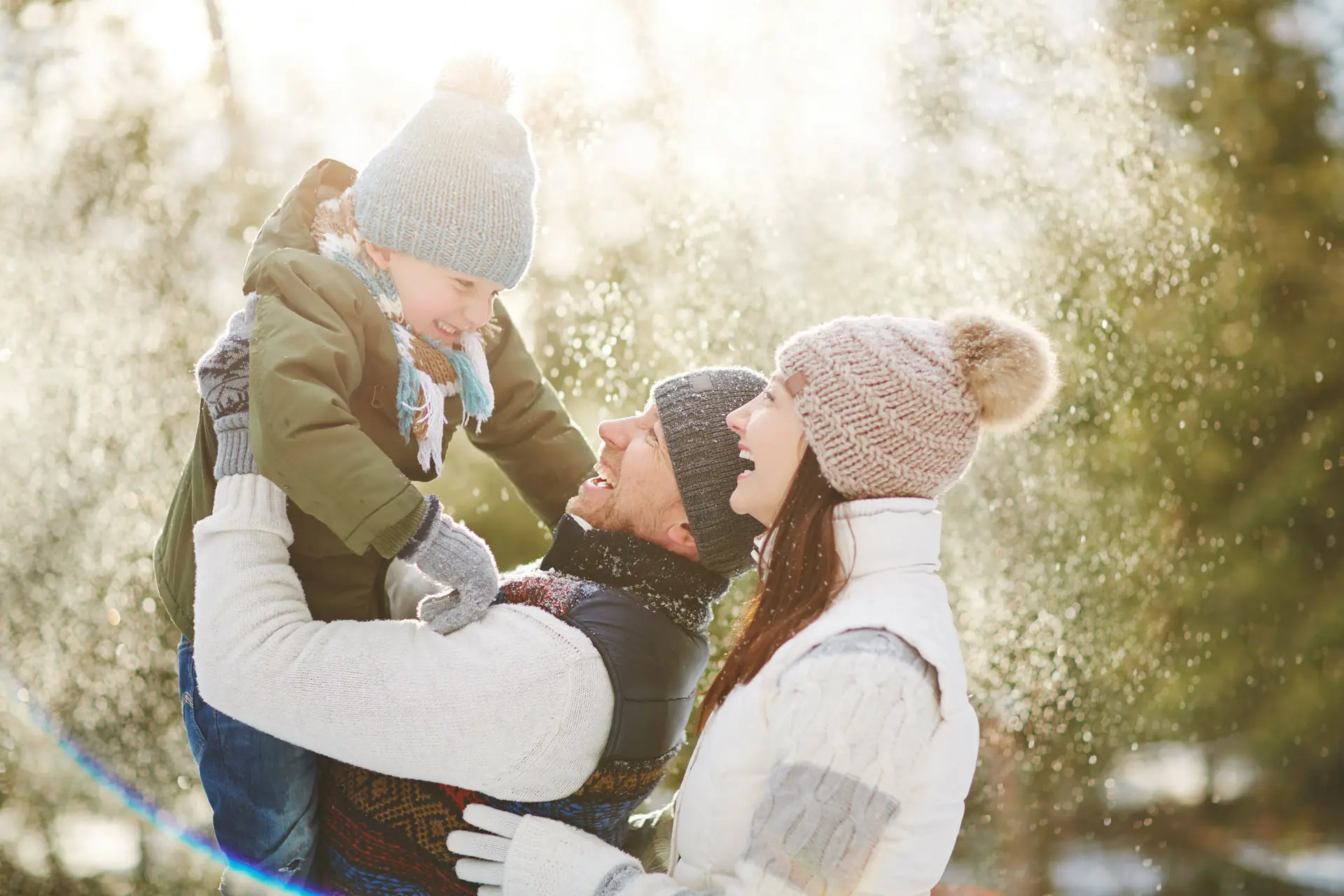 Parents holding their child in the air in the snow