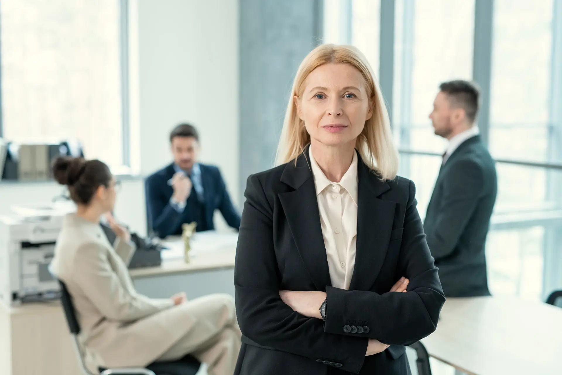 Portrait of a business woman with people having a business meeting behind her