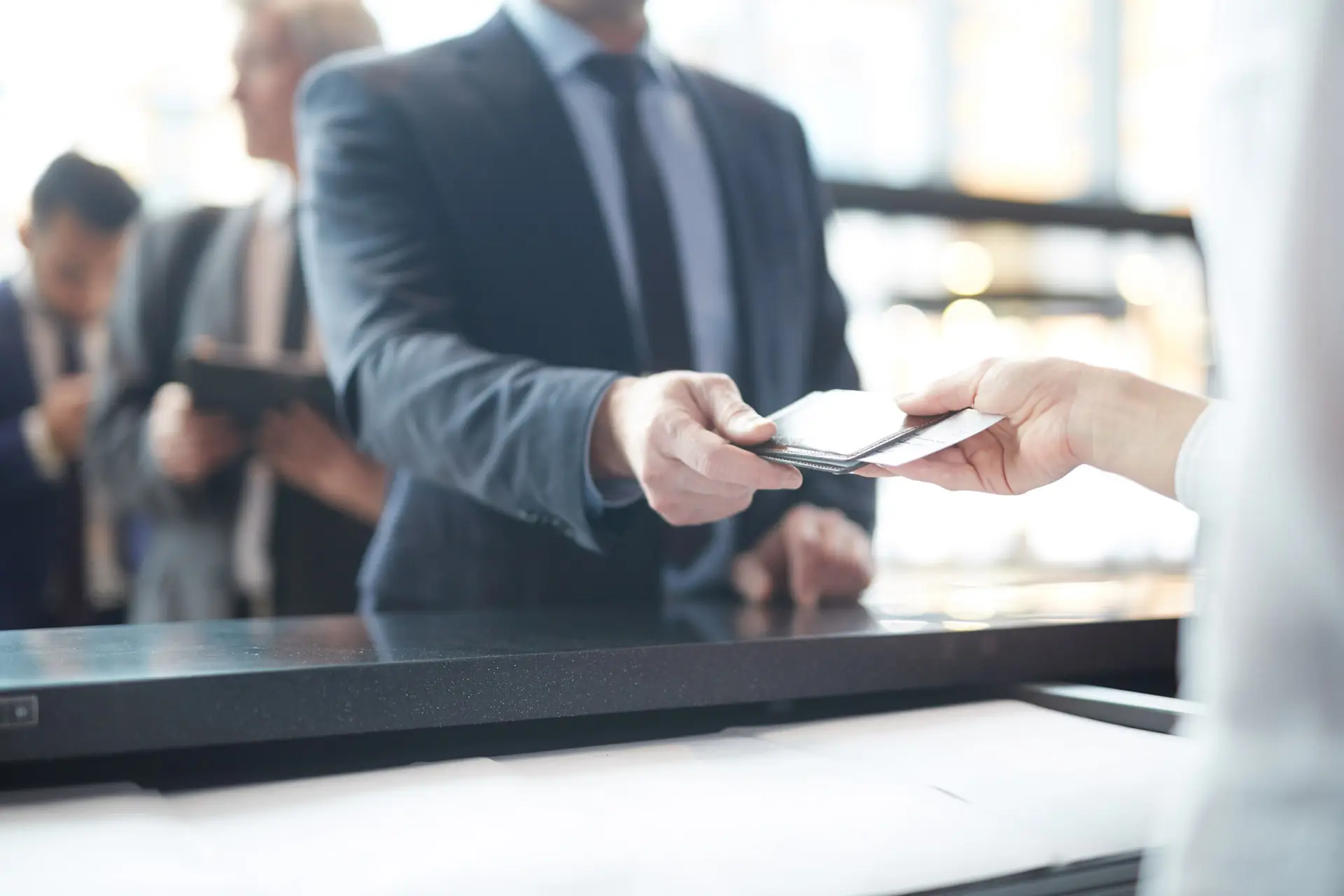 Man in a suit handing money to a credit union teller