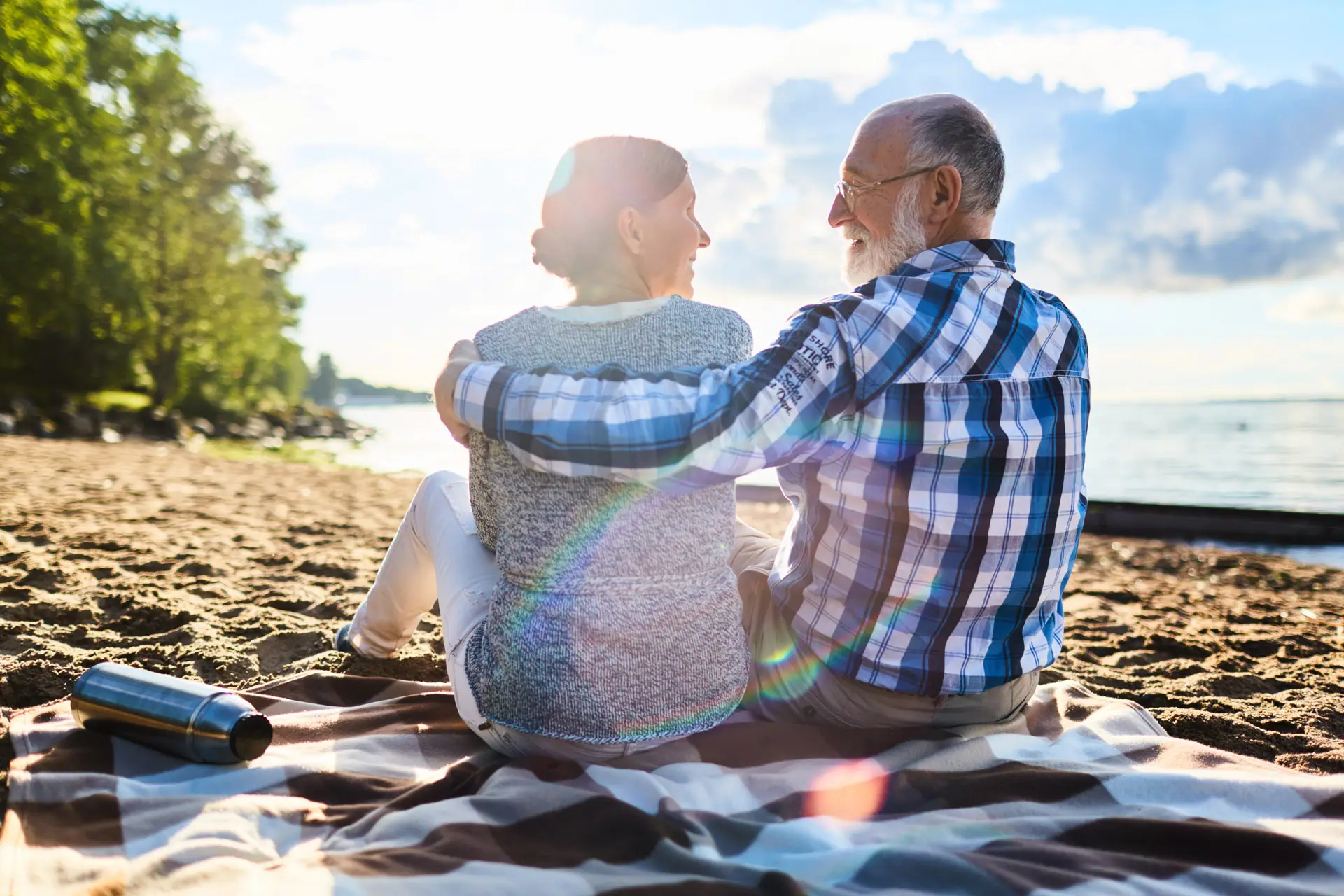 Couple hugging and smiling at each other on the beach