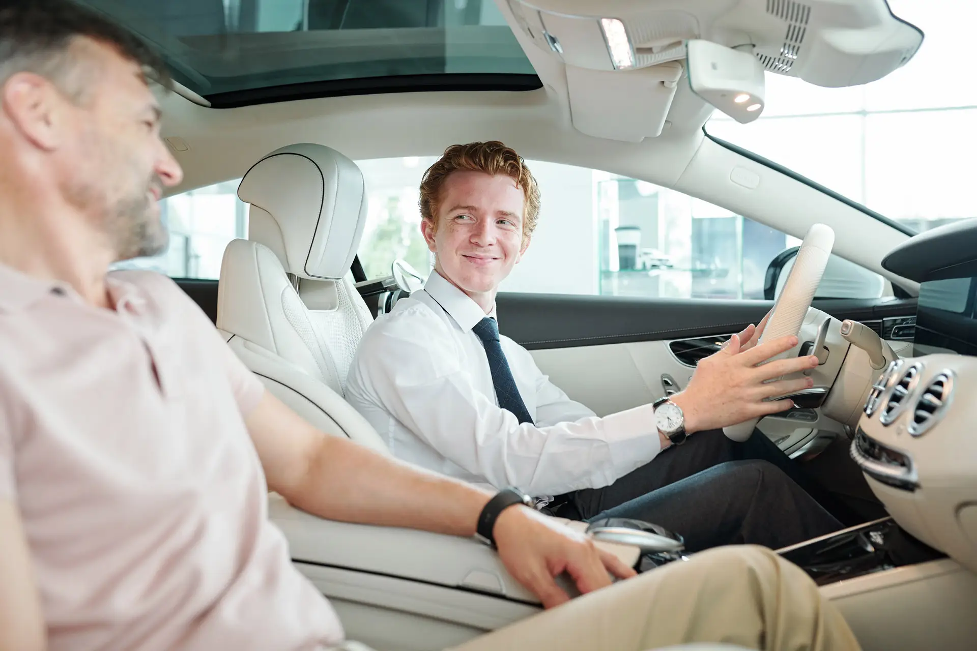Car salesman in a car with a customer