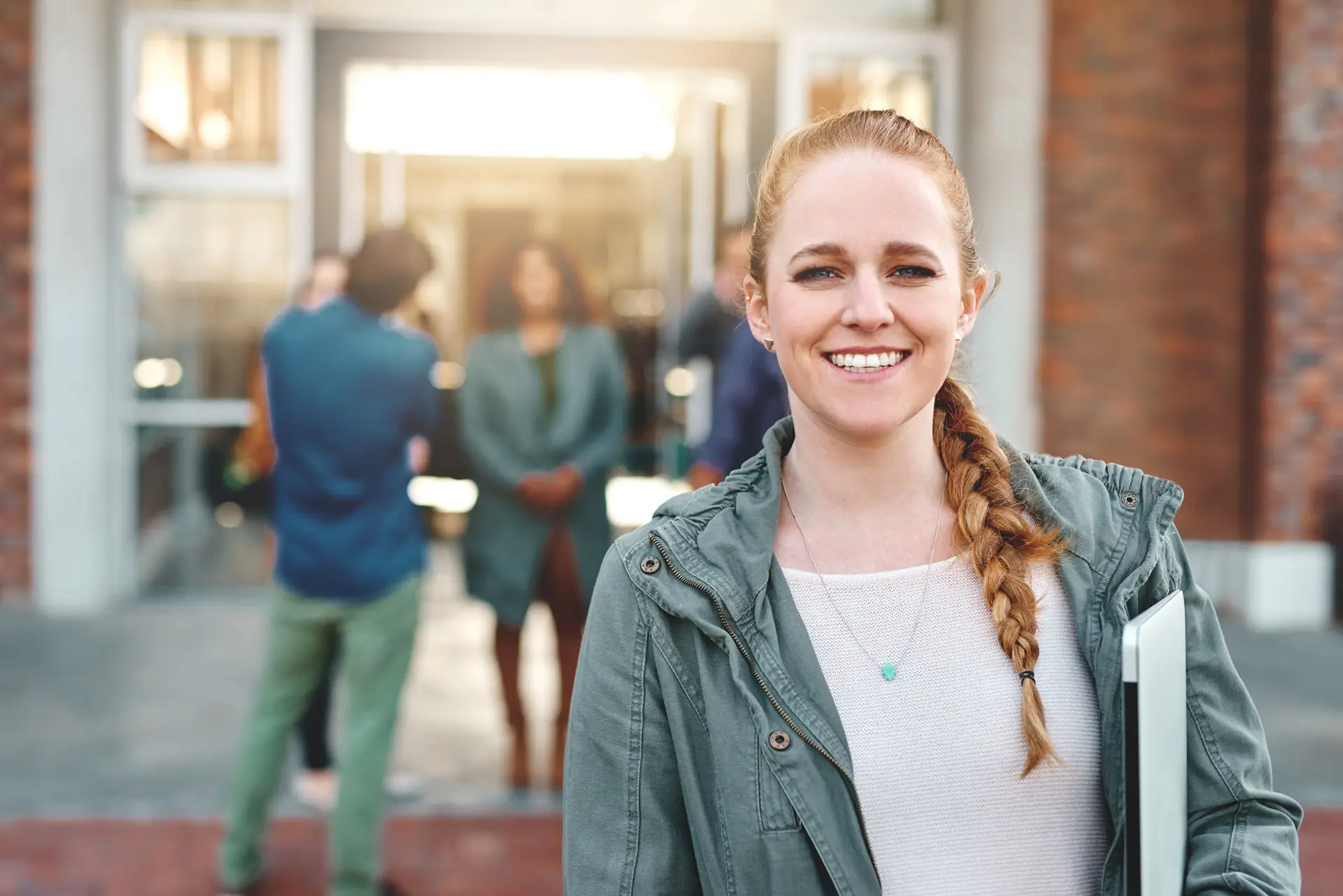 College student smiling in front of a college building