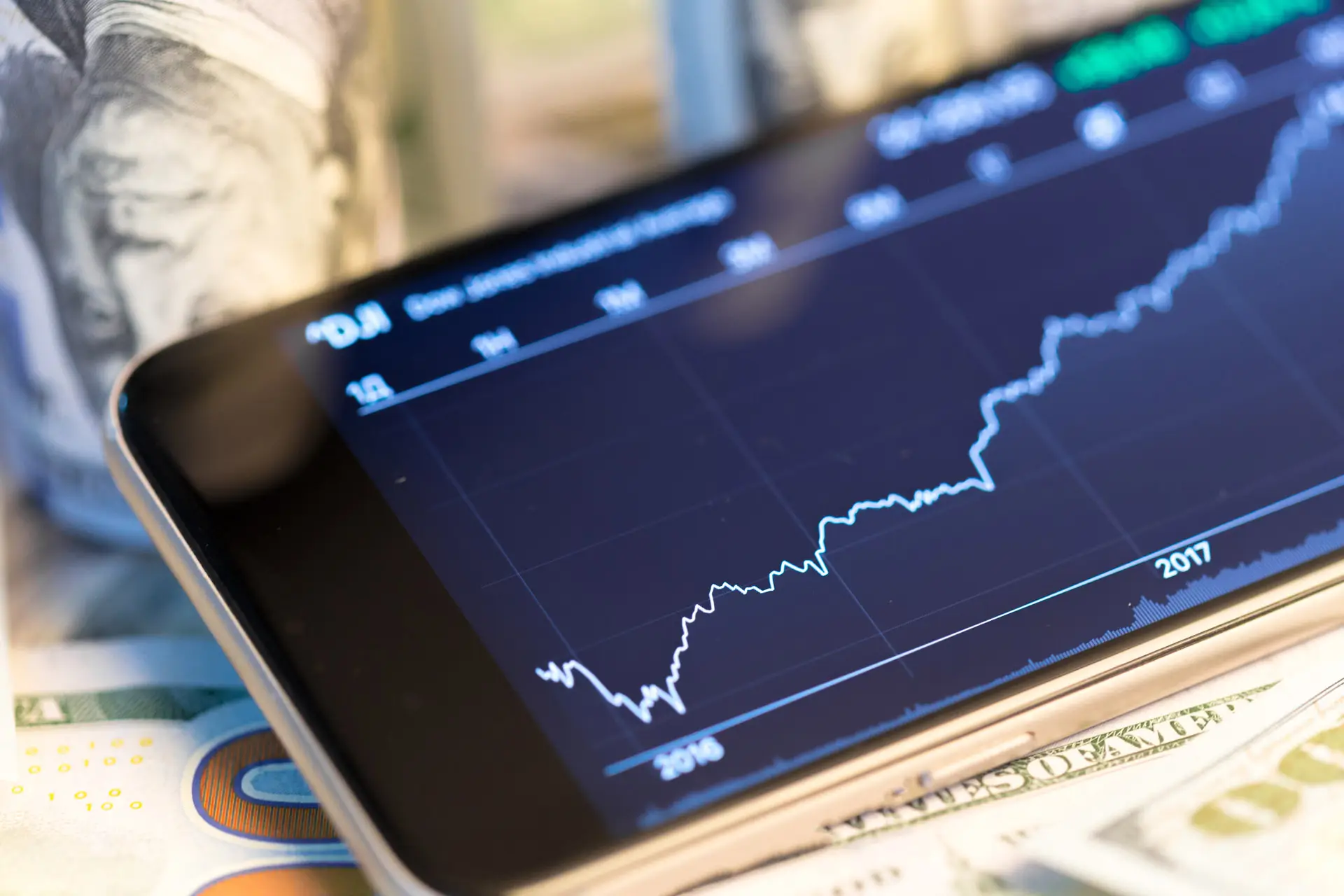 Phone with a stock growth chart going upwards